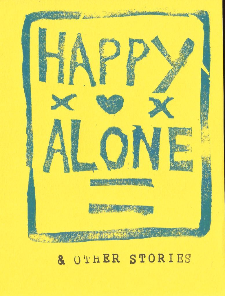A cover from a zine by Seleena Laverne Daye. It is yellow and has the words 'Happy Alone' painted in blue writing with a heart and two 'x' in the middle
