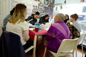 Kitt at table chatting to group of people doing crafts