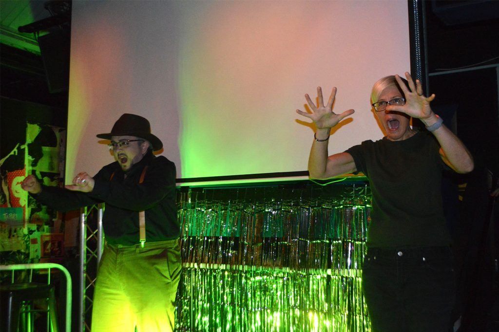 Drag king Mr Brake Down performs gestures with his hands onstage with Becky Mayo signing