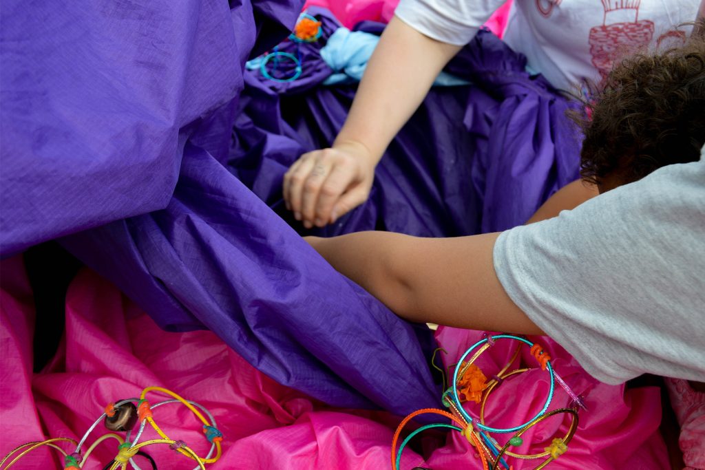 small hands in between pink and purple fabric as part of Lady Kitt's installation Visible Rest