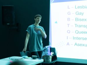 Finn is speaking in front of a screen with a session plan projected onto it